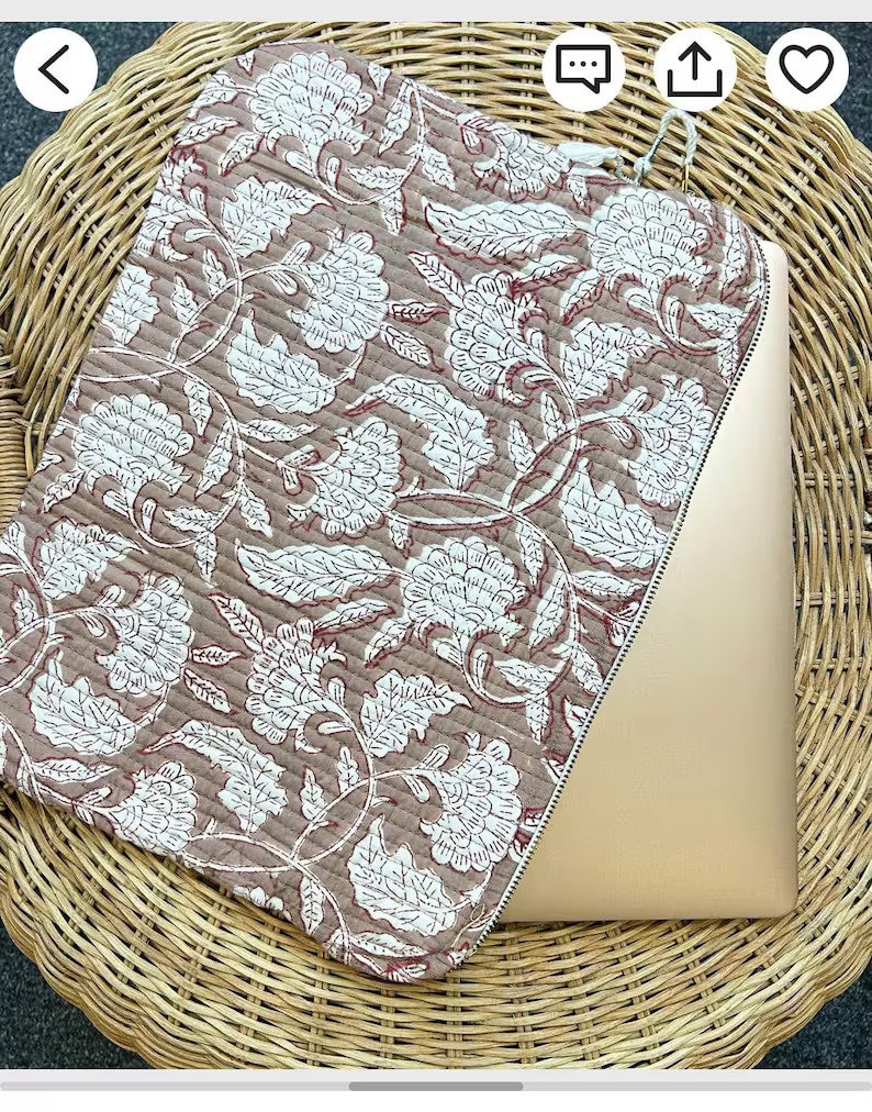May include: A brown and white floral laptop sleeve with a zipper closure. The sleeve is made of quilted fabric and has a traditional Indian design.