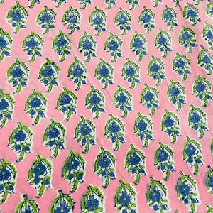 May include: Pink fabric with a repeating pattern of blue and green floral designs.
