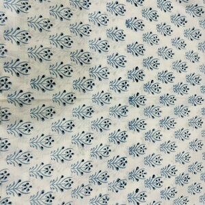 May include: White fabric with a repeating pattern of blue floral sprigs. The sprigs are stylized and have a simple, elegant design.