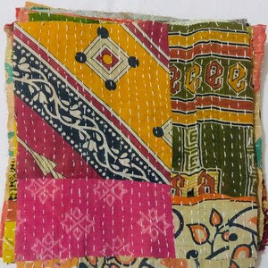 May include: A patchwork quilt made from colorful fabric scraps. The quilt is hand-stitched and features a variety of patterns, including floral, geometric, and paisley designs. The quilt is a vibrant mix of yellow, orange, pink, green, and brown.