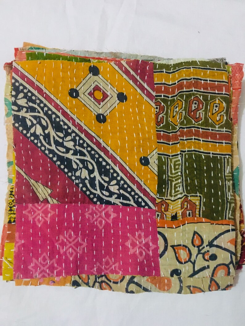 May include: A patchwork quilt made from colorful fabric scraps. The quilt is hand-stitched and features a variety of patterns, including floral, geometric, and paisley designs. The quilt is a vibrant mix of yellow, orange, pink, green, and brown.