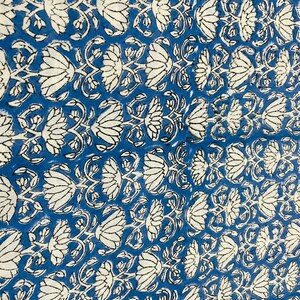 May include: Blue fabric with a white floral pattern. The pattern features stylized lotus flowers with intricate details.