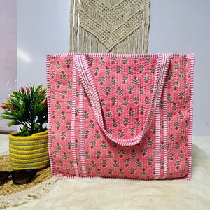 Pu&ograve; includere: Una borsa tote rosa e bianca con stampa floreale. La borsa ha due manici ed &egrave; realizzata in tessuto trapuntato.