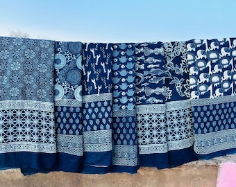 May include: Six indigo blue cotton fabric panels with white block printed designs. The designs include geometric patterns, circles, keys, teapots, fish, and elephants.