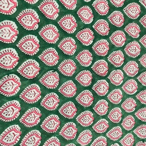 May include: Green fabric with a repeating pattern of pink and white leaf designs.