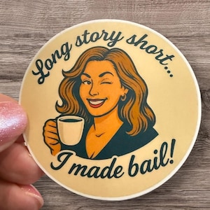 May include: Round sticker with a retro illustration of a woman winking and holding a coffee cup. The text reads "Long story short... I made bail!" in a vintage font. The sticker has a cream background.