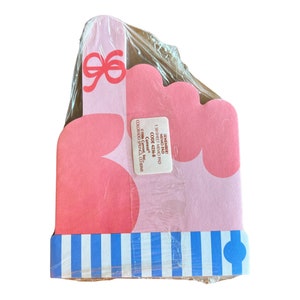 May include: A pink memo pad with a bow design and a blue and white striped border. The memo pad is wrapped in clear plastic. The text on the memo pad reads "REMEMBER! MEMO PAD 150-SHEET MEMO PAD CODE 4236-8".