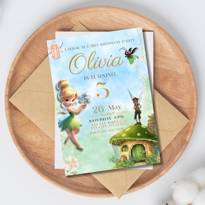 Op de afbeelding: Een uitnodiging voor een verjaardagsfeestje met een feeënthema, met de naam "Olivia" en het getal "5" in goud. De datum is 26 mei, met tijd en adresgegevens eronder. De uitnodiging ligt op een houten dienblad, met een bruine envelop.
