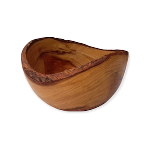 Puede incluir: Un cuenco de madera natural con una forma única e irregular. El cuenco está hecho de madera marrón claro con un acabado liso y pulido.