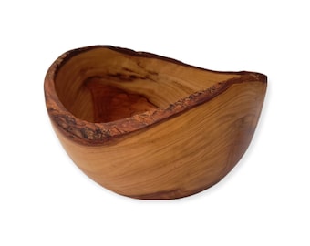 May include: A natural wood bowl with a unique, irregular shape. The bowl is made from a light brown wood with a smooth, polished finish.