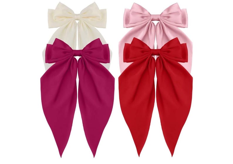 May include: Three large satin hair bows in different colours. The bows are tied in a knot and have long tails. The colours are white, pink, and red.
