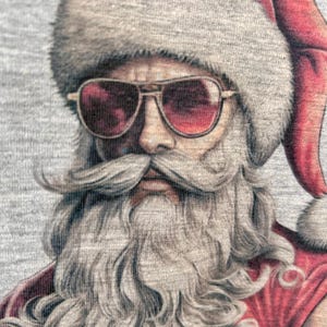 May include: A close-up of a Santa Claus with a gray beard and sunglasses. He is wearing a red and white hat and a red shirt.