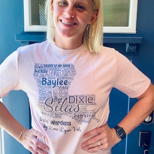 May include: A pink t-shirt with a black word cloud design featuring names such as "Silas", "Baylee", "Dixie", and "Warden's". The text "by Lani Lynn Vale" is printed below the word cloud.