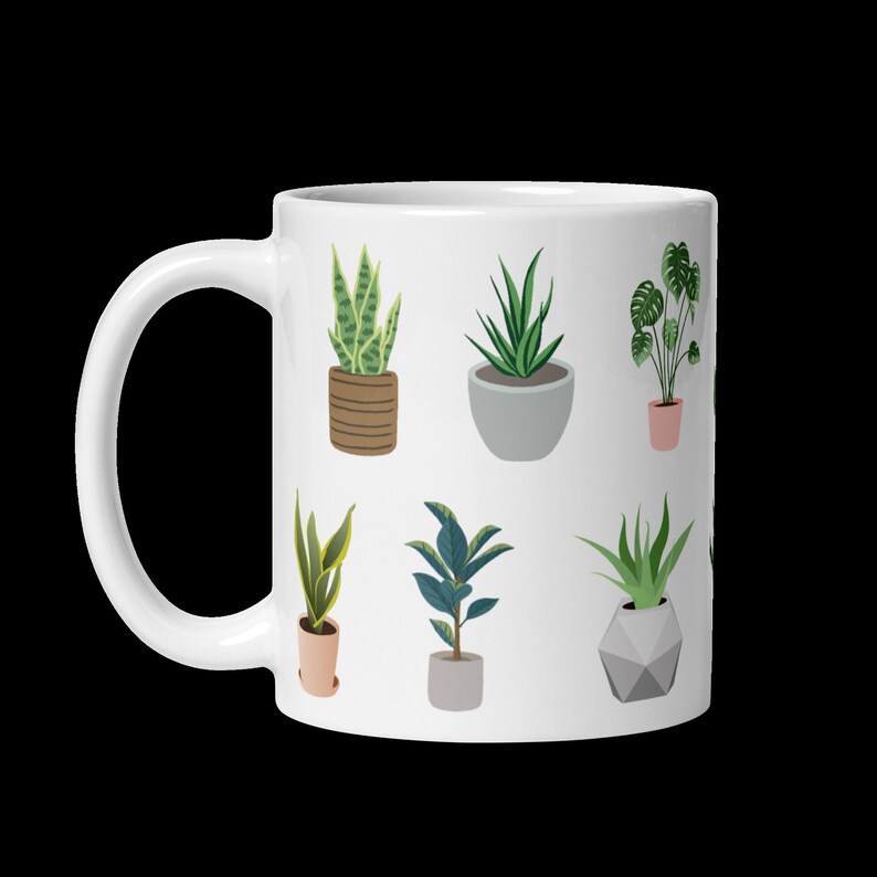 May include: White ceramic mug featuring a repeating pattern of various potted plants in shades of green, brown, and gray. The plants include snake plants, aloe vera, and a monstera. The mug has a curved handle.