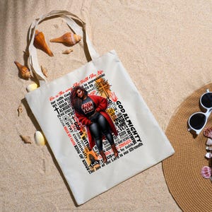 K&ouml;nnte beinhalten: Eine wei&szlig;e Einkaufstasche mit einem schwarzen und roten Design, das eine Frau mit einer roten Jacke und einer schwarzen Hose zeigt. Die Tasche hat ein Zitat &uuml;ber Glauben und Gott. Der Text auf der Tasche lautet: "He is the way The truth The Life for with God WE LOVE BECAUSE is impossible ED US lovel GOD ALMIGHTY FEAR ENDS THE FAITH WALK BY FAITH KING OF KINGS new day new mercies pray continually GOD IS WITHIN R LIV FAITH FEAR COD AITH LET CO AND GOD TRUS IN THE LORD ESUS and follow GHD GOD HAD OMEGA COD THE LORD USwk by faith GOD ALMIGHTY The Joy of the Lord is my Strength"