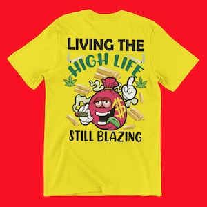 Könnte beinhalten: Gelbes T-Shirt mit einem Cartoon-Geldbeutel, der einen Joint raucht, und dem Text "Living the High Life Still Blazing".