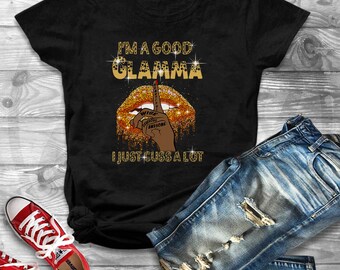 Op de afbeelding: Zwart T-shirt met gouden glittertekst die "I'm a good Glamma I just cuss a lot" zegt met een gouden glitterlipontwerp en een vinger over de lippen.