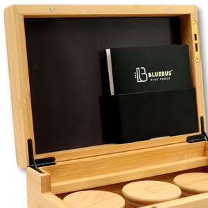 K&ouml;nnte beinhalten: Offene Bambusbox mit schwarzem Innenraum und Klappdeckel. Im Inneren befindet sich eine schwarze Tasche mit einer wei&szlig;-schwarzen Karte mit dem Text "BLUEBUS FINE TOOLS". Drei runde Untersetzer aus Holz sind unten sichtbar.