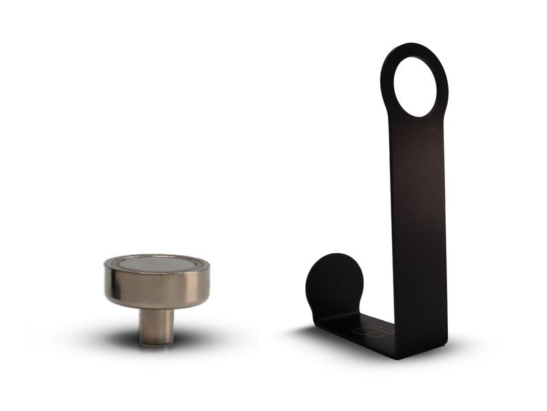 Puede incluir: Un gancho de metal negro con una abertura redonda en la parte superior y una base curva. Tambi&eacute;n se muestra un gancho magn&eacute;tico plateado con una base redonda.