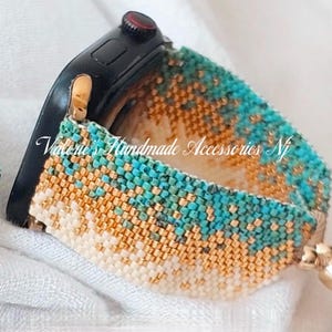 May include: A turquoise, gold and white beaded watch strap. The strap is made of small, square beads and is attached to a black smartwatch.