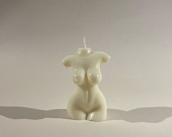 Puede incluir: Una vela blanca con forma de torso humano.