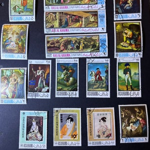 May include: A collection of vintage postage stamps from Ras Al Khaimah, United Arab Emirates. The stamps feature various religious and cultural themes, including Christmas scenes, religious figures, and traditional Japanese art.