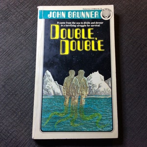 May include: A paperback book cover with a black background and a yellow title "DOUBLE, DOUBLE". The cover features two men standing in a snowy landscape with a green sea monster rising from the water behind them.