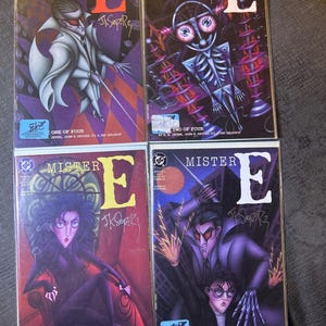 May include: Four comic book covers featuring the title "Mister E" with a large letter "E" in the background. The covers feature different characters and artwork in a dark, gothic style. The covers are numbered one through four.