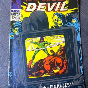 May include: A vintage comic book cover featuring Daredevil, a superhero with red and black costume, fighting a villain in a green jester costume. The cover is yellow and red with the title "DAREDEVIL" in large, bold letters. The text "the FINAL JEST!" is printed at the bottom of the cover.