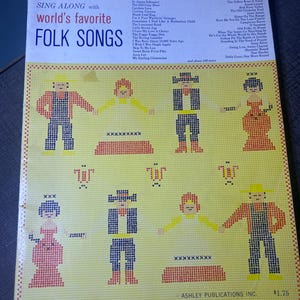 May include: A vintage record album cover for "Sing Along with World's Favorite Folk Songs." The cover has a yellow background with cross-stitch style figures. The album includes a list of folk songs.