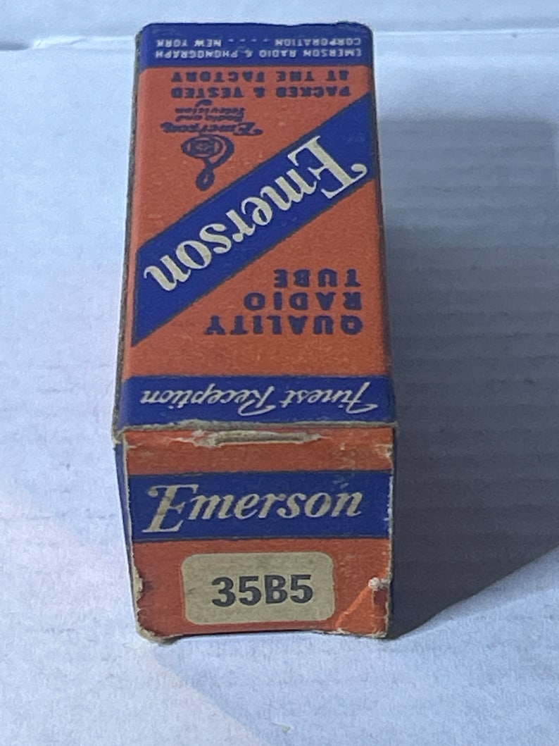 May include: A vintage box for a 35B5 radio tube. The box is orange with blue text and a blue and white logo. The text on the box reads "Emerson Quality Radio Tube Finest Reception".