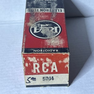 May include: A red and black box with the text "RCA Radiotron" and "ELE.  TRON TUBE" printed on it. The box has a white logo with a lightning bolt and the letters "RCA" in a circle. The box is labeled "5DJ4".