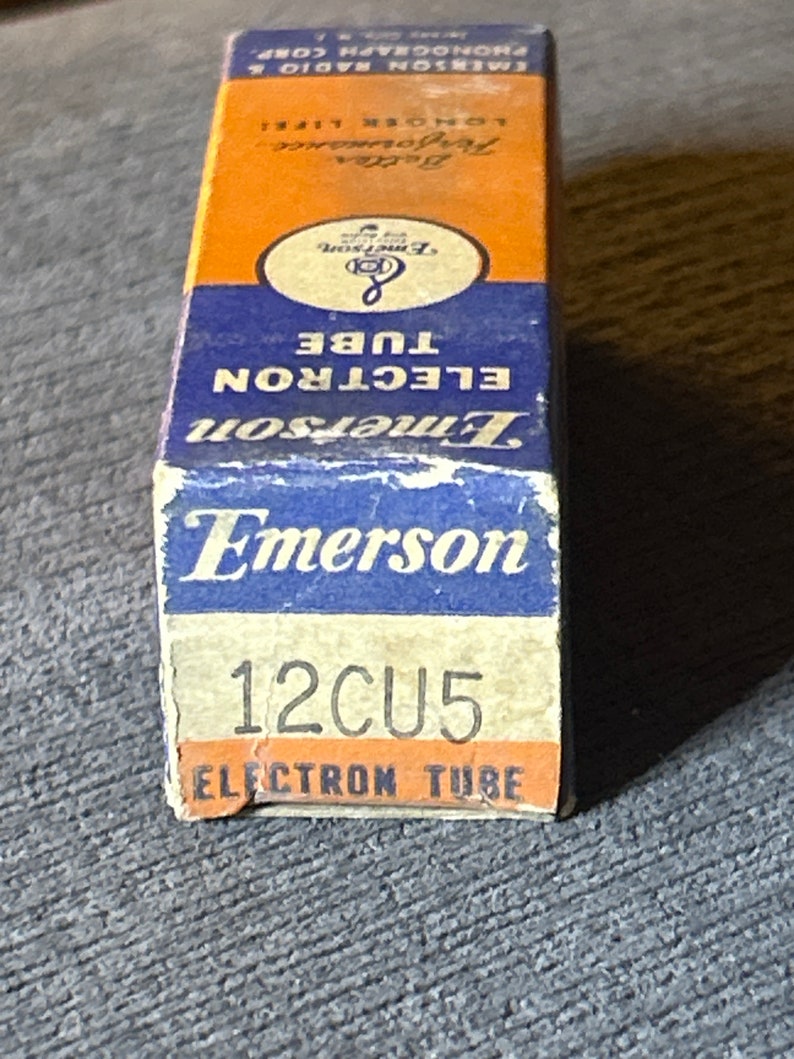 以下が含まれることがあります： 青と白の箱に「Emerson 12CU5 Electron Tube」と印刷されています。箱は電子真空管用です。