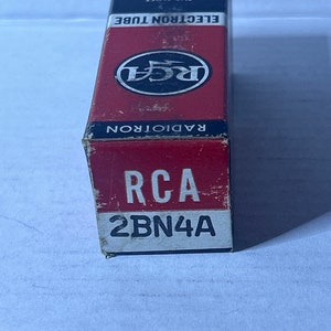 May include: A red and white box with the text "RCA ELECTRON TUBE" and "THE MOST TRUSTED NAME IN ELECTRONICS". The box also has a large RCA logo and the text "RADIOTRON" and "RCA 2BN4A".