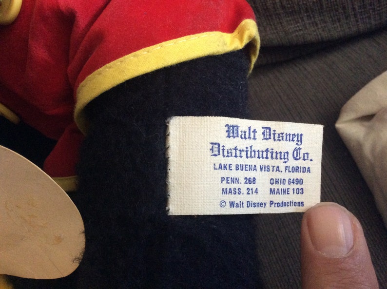 May include: White tag with black text that reads "Walt Disney Distributing Co. Lake Buena Vista, Florida Penn. 268 Ohio 6490 Mass. 214 Maine 103 &copy; Walt Disney Productions"
