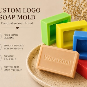 Può includere: Stampi per sapone colorati, verde, giallo, blu e rosso, con una saponetta beige in primo piano. La saponetta beige ha il testo "Waxa2bal" in rilievo. L'immagine include anche il testo "Custom Logo Soap Mold".