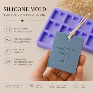 Pode incluir: Um molde de silicone roxo para ambientadores sólidos com uma grade de cavidades quadradas. Um ambientador quadrado azul com o texto em relevo CUSTOM TEXT e um símbolo de coração está preso a um cordão bege em frente ao molde.