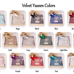 May include: A collection of velvet Yaseen covers in various colors, including aqua, beige, black, blue, burgundy, dark violet, gold, gray, green, light blue, navy blue, pink, purple, red, teal, and white. Each cover is displayed in a clear plastic box with a gold trim and a decorative bow.