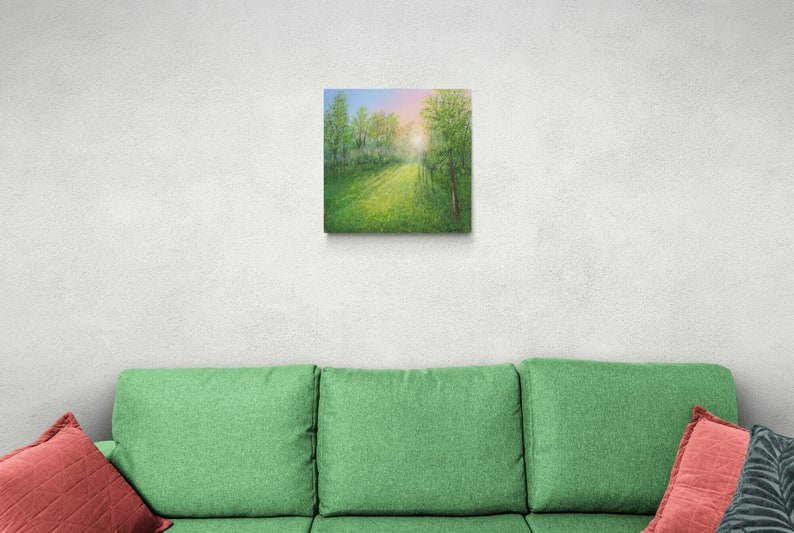 Puede incluir: Arte en lienzo cuadrado que representa un sendero forestal soleado. La pintura presenta un prado verde vibrante que conduce a una abertura brillante y soleada. Los &aacute;rboles bordean el camino, con un cielo azul y rosa visible arriba.
