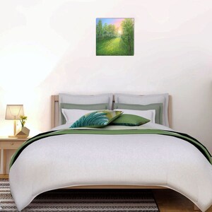 Puede incluir: Una pintura cuadrada de una escena de bosque soleado cuelga sobre una cama con ropa de cama blanca y detalles en verde. Una peque&ntilde;a mesita de noche con una l&aacute;mpara y una planta est&aacute; a la izquierda. Un globo terr&aacute;queo y una planta est&aacute;n a la derecha.