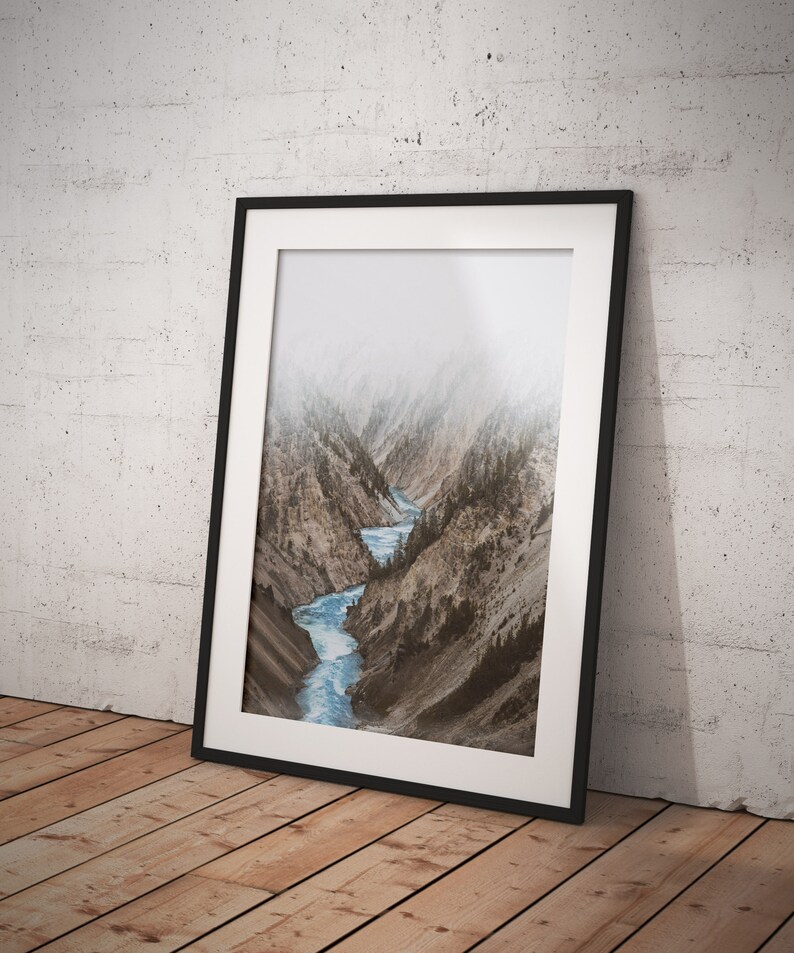 May include: A framed photograph of a river winding through a mountain canyon. The photo is in black and white with a muted blue river.