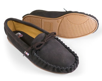 May include: A pair of brown suede moccasins with a leather sole and a decorative stitching detail around the toe. The moccasins have a leather lining and a comfortable fit.