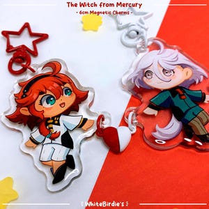Può includere: Due ciondoli magnetici da 6 cm con personaggi anime dello show "The Witch from Mercury". Un ciondolo è di una ragazza con i capelli rossi e un vestito bianco e blu. L'altro ciondolo è di una ragazza con i capelli bianchi e un vestito verde e marrone.