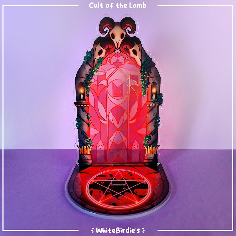 May include: A decorative acrylic stand featuring a stylized red and pink stained-glass door with a pentagram on the base. The stand has a skull design at the top and the text "Cult of the Lamb" is visible at the top.