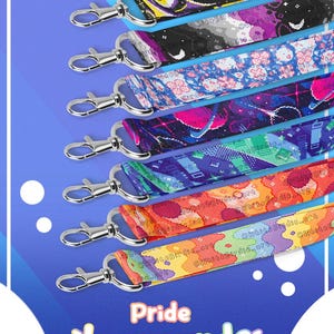 Può includere: Una collezione di otto cordini in tessuto con chiusure a moschettone in metallo argentato, ognuno con distinti motivi pixel art colorati e il testo @WhiteBirdie.art. L'immagine include il testo Pride Lanyards e WhiteBirdie's.