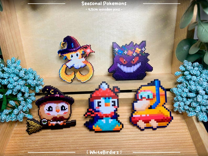 May include: Six 4.5cm wooden pins featuring pixel art designs of Pokemon characters. The pins are themed around different seasons: a witch-like Pokemon, a flower-crowned ghost Pokemon, a penguin Pokemon, a ghost Pokemon with a pumpkin, a Pokemon wearing a Santa hat, and a Pokemon wearing a swimsuit.