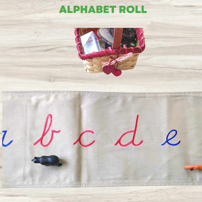 May include: A beige fabric alphabet roll with the letters b, c, d, and e embroidered in red and the letter a embroidered in blue. A black toy animal is on the roll.