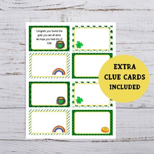 Op de afbeelding: Printbare St. Patrick's Day speurtocht-aanwijzingskaarten met groene klaverblad- en gouden muntontwerpen. De kaarten hebben lege ruimtes waar je je eigen aanwijzingen kunt schrijven. De tekst op de kaart luidt "Extra aanwijzingskaarten inbegrepen".