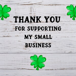 Op de afbeelding: Witte houten achtergrond met de tekst "THANK YOU FOR SUPPORTING MY SMALL BUSINESS" in zwarte letters. Drie groene vierbladige klaverblaadjes zijn rond de tekst geplaatst.