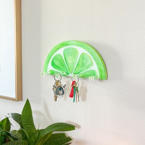 Artistic wall-mounted key holder crafted to resemble a fresh lime slice, ideal for adding a zesty touch to home decor